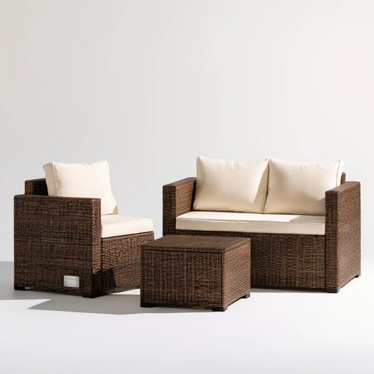 Brązowy zestaw wypoczynkowy z technorattanu z kremowymi poduszkami: sofa 130 × 70 × 75 cm, fotel 75 × 70 × 75 cm, stolik 80 × 45 × 40 cm